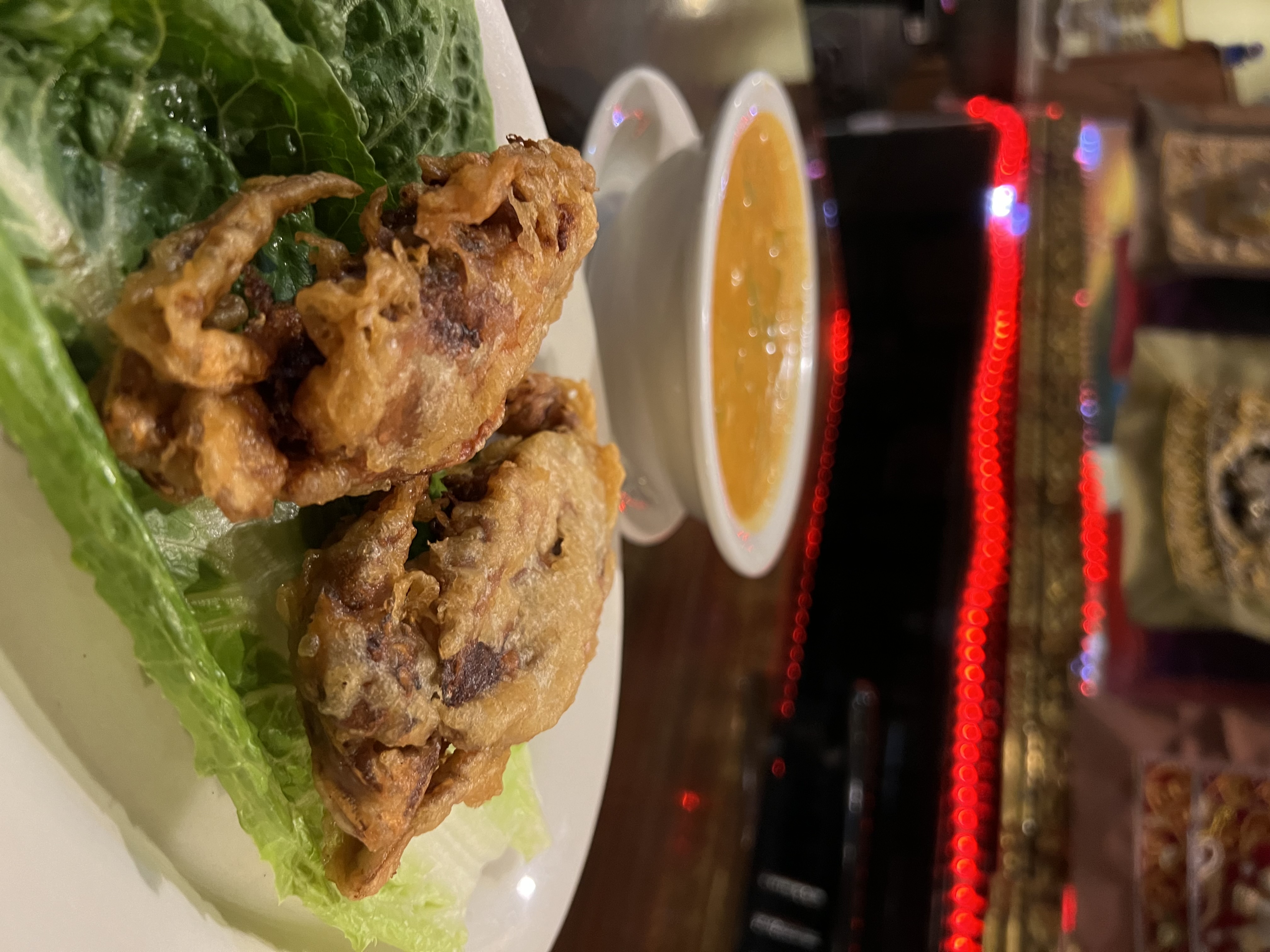 two fried soft-shell crabs on lettuce, served with a bowl of panang curry