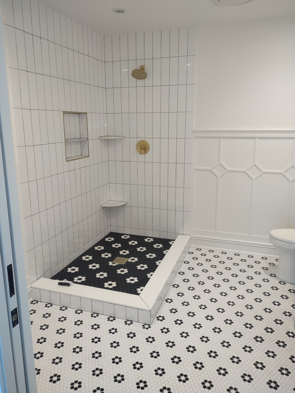 white and black tiled shower area in bathroom